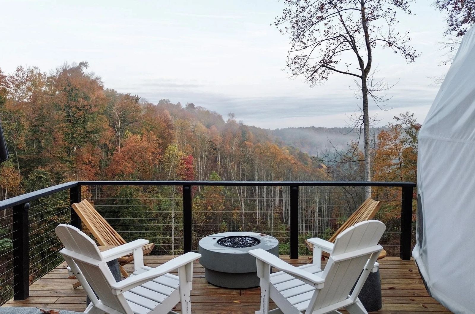 Deck with fire pit and Adirondack chairs overlooking the ridgeline at Short Mountain Holiday