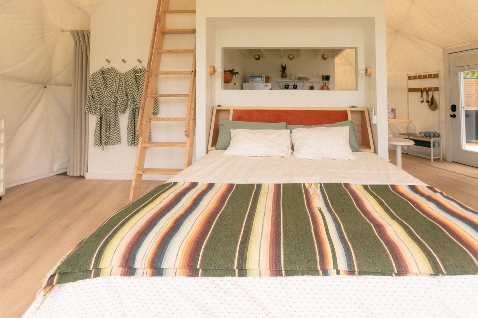 King bed with loft ladder inside a geodesic dome at Short Mountain Holiday