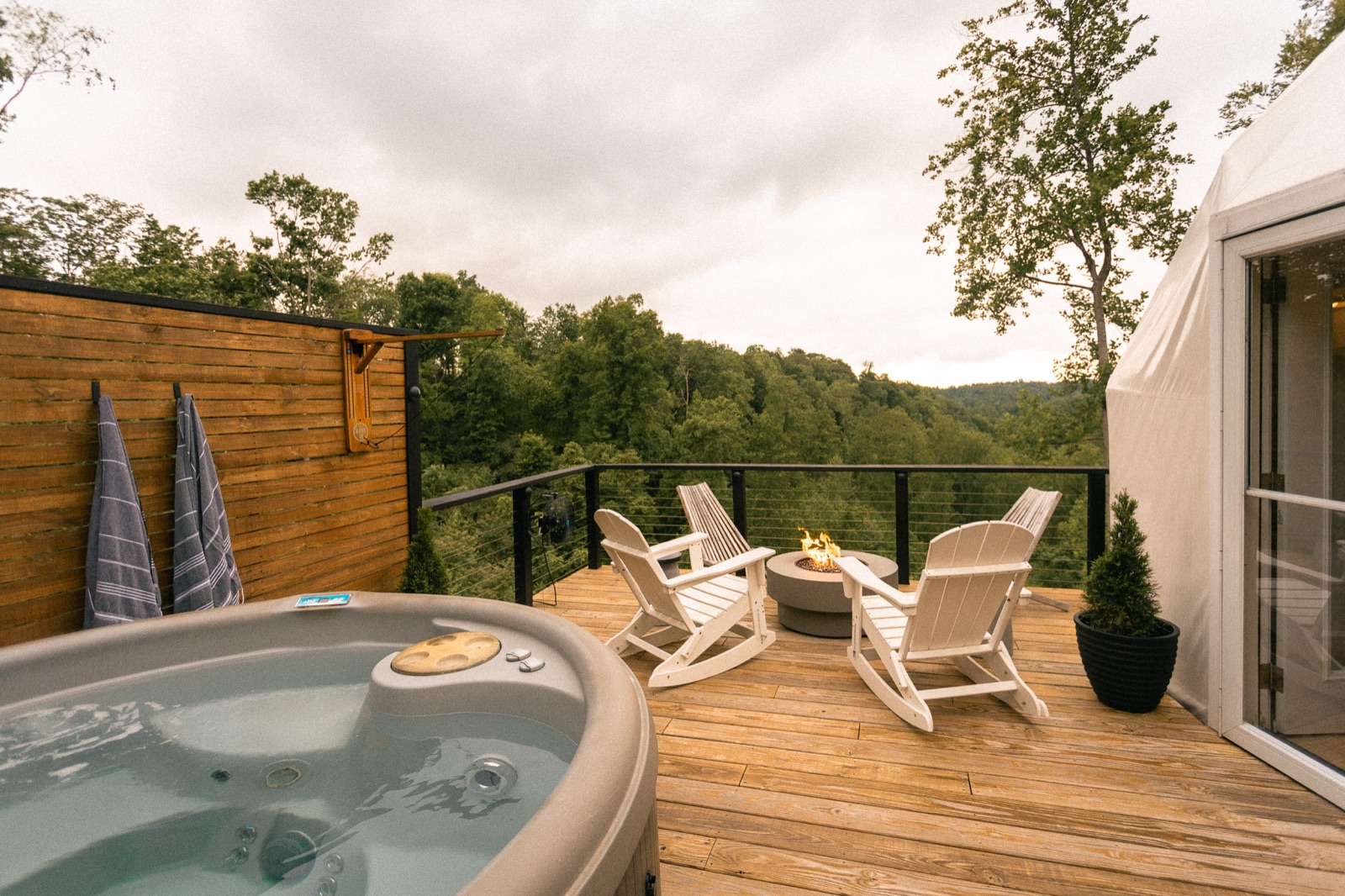 Private hot tub and Adirondack chairs on the deck overlooking the forest at Short Mountain Holiday