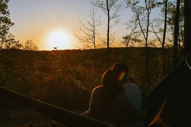 Couple in a hammock watching the sun set over the ridge from the property