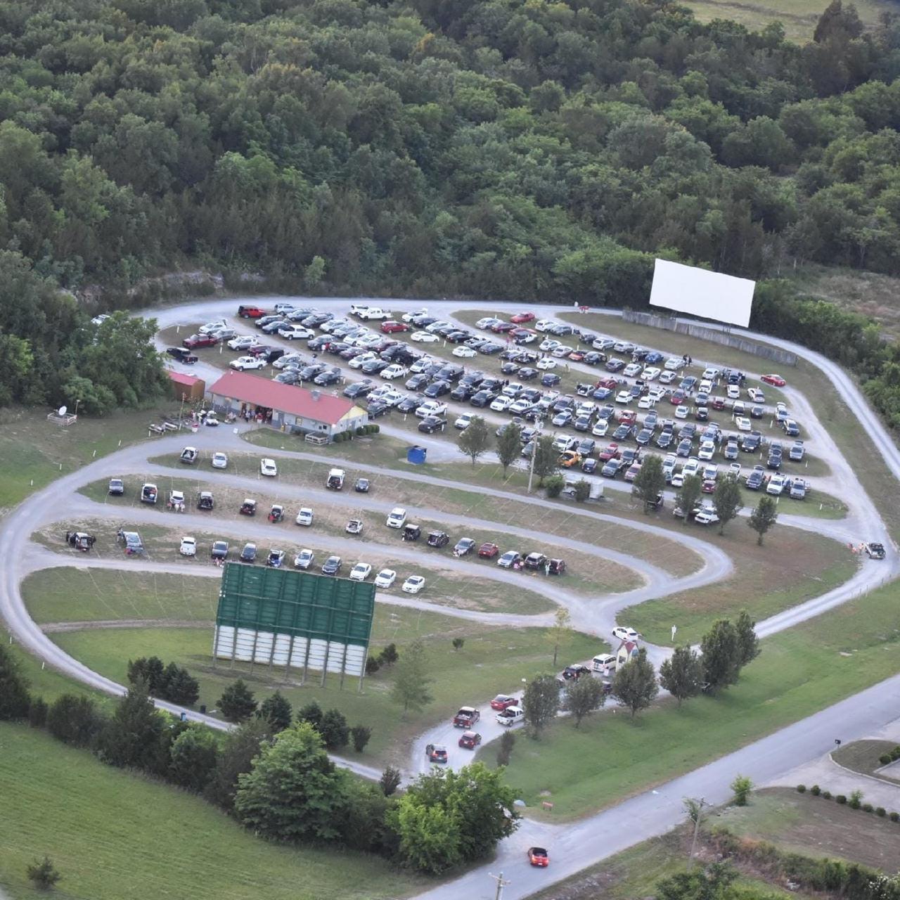 Aerial view of Stardust Drive-In Theater in Watertown — looped driveway full of cars facing the screen at dusk, surrounded by Tennessee forest